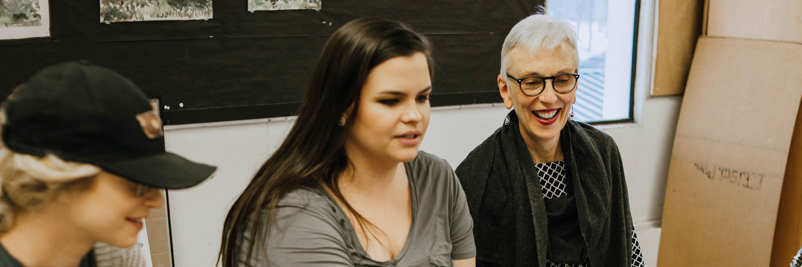 Two future art teachers meet with their professor.