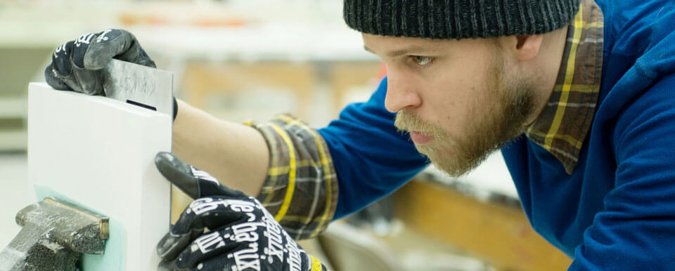 Student measures a piece of foam for his project.