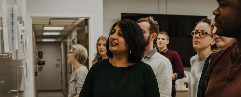 A graphic design professor and her students critique designs together.