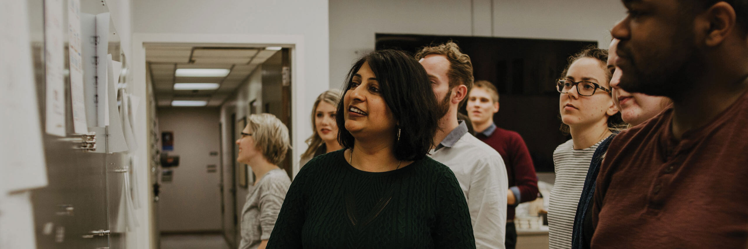 A graphic design professor and her students critique designs together.