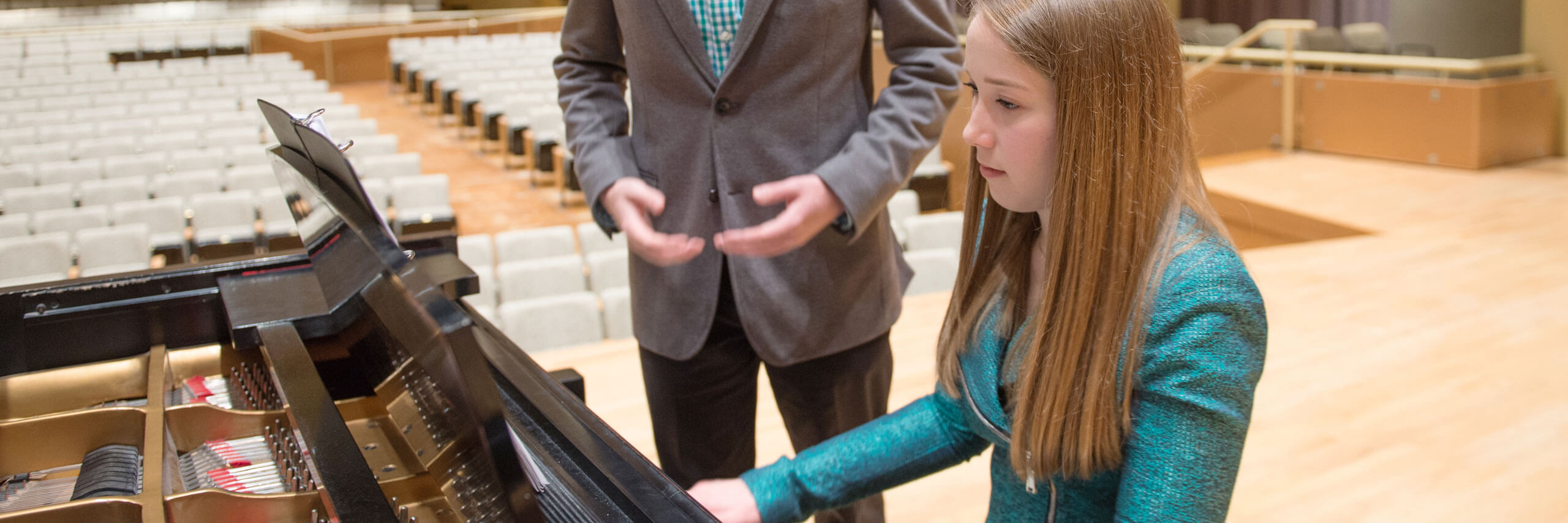 A pianist accompanies another student while he sings.
