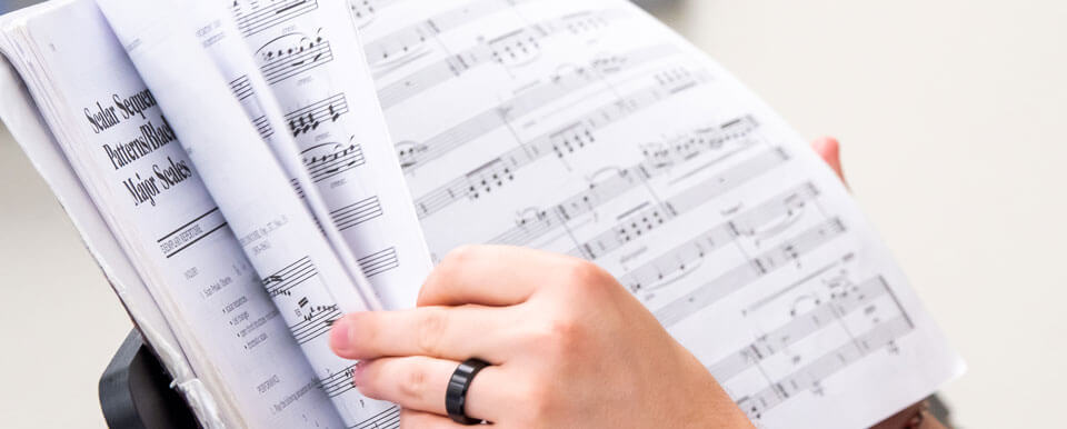 Student flips through his sheet music.