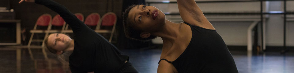 Dance students stretch before rehearsal.