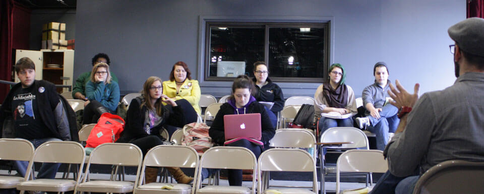 Theatre professor lectures to a group of students.