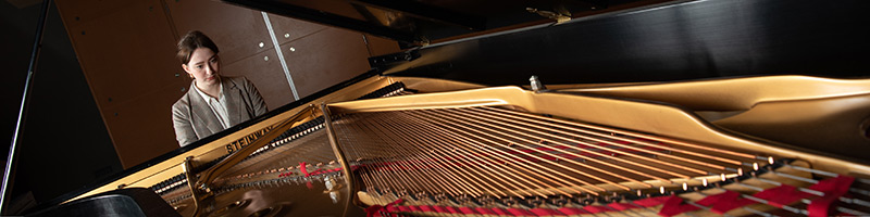 Student playing grand piano