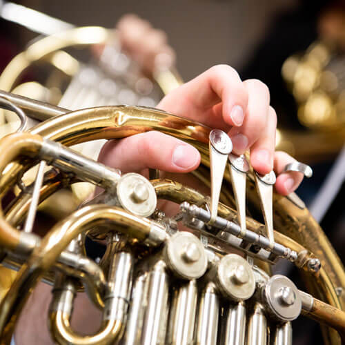 Students plays their french horn.