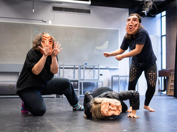 Theatre students wear masks that they created.